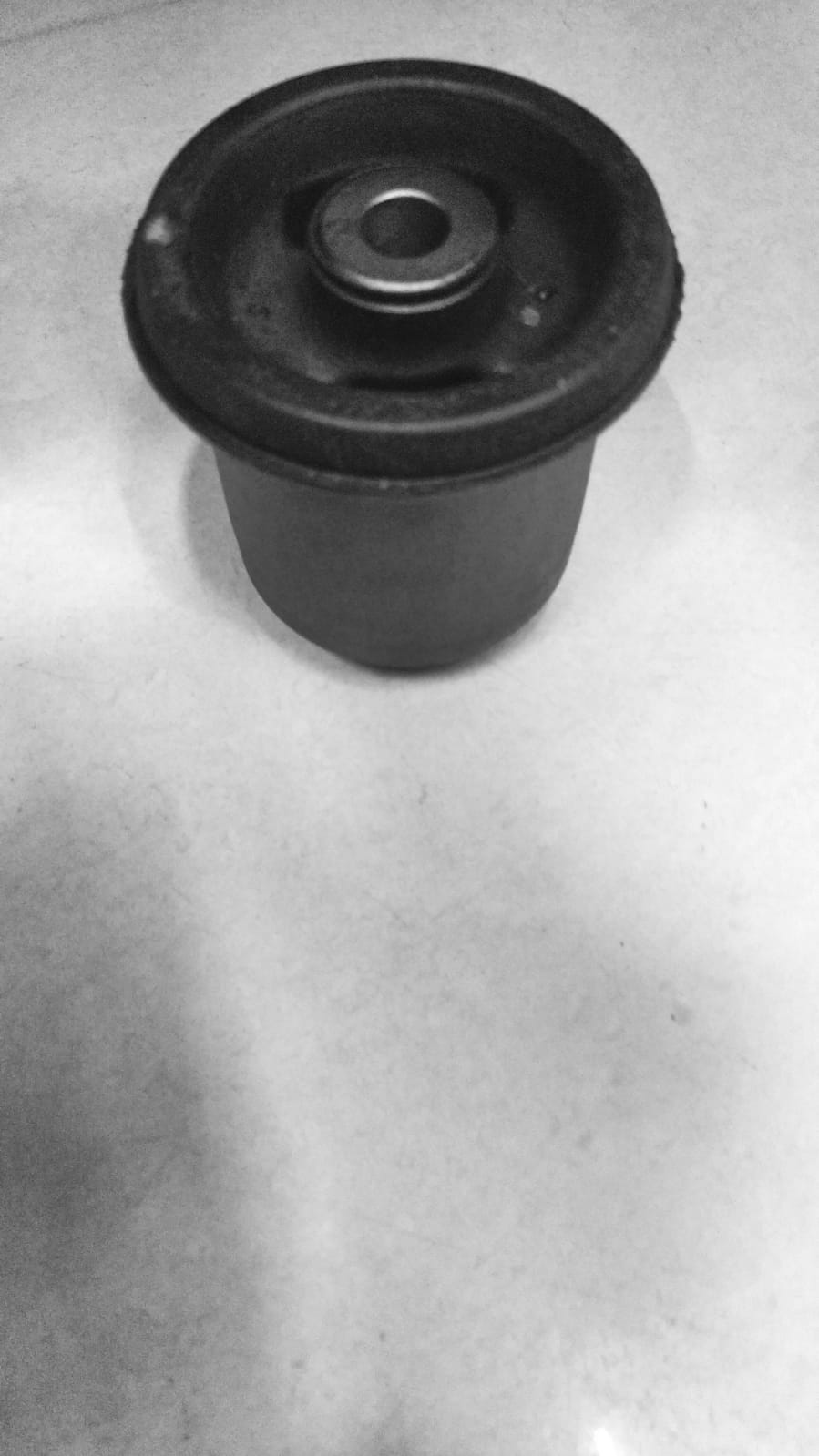 CarTrends trailing arm bushing spare part, close-up of the black rubber bushing for vehicle suspension repair.