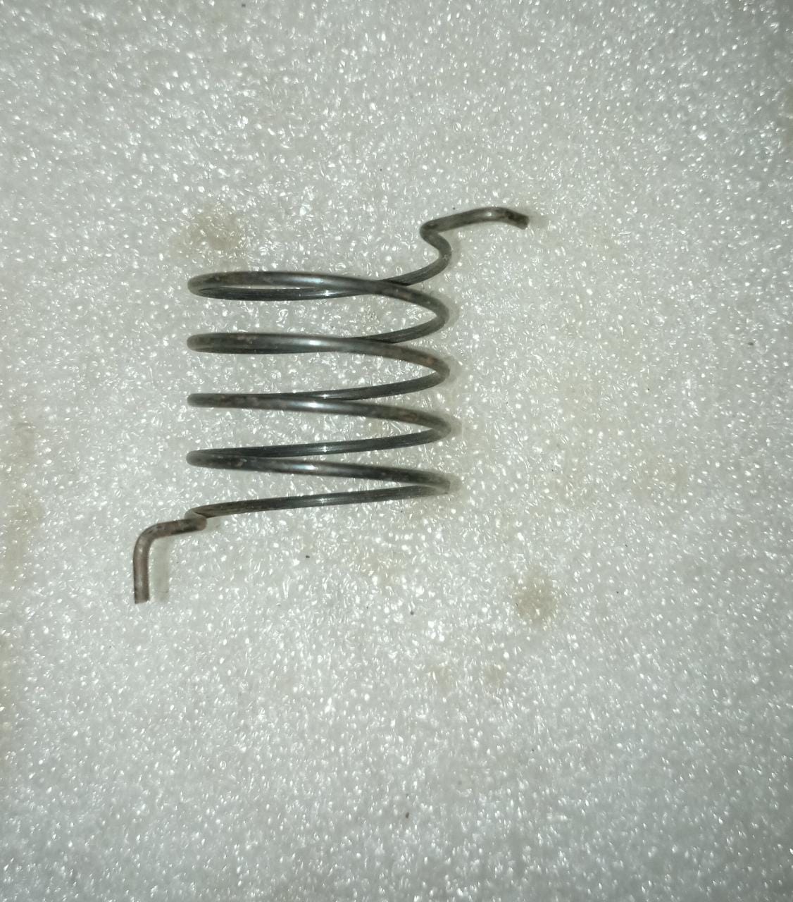 CarTrends J96325078 return spring for Aveo, a spare automotive part shown in the image.