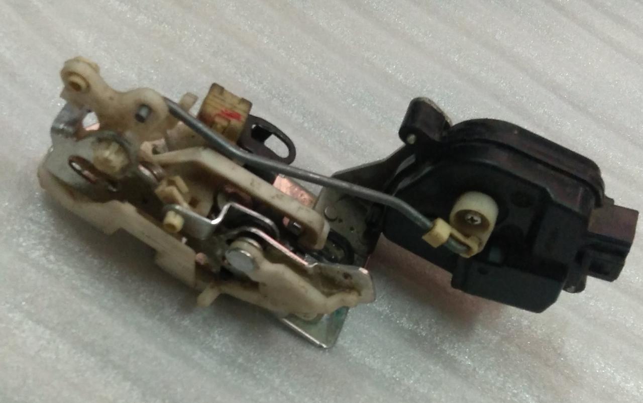 CarTrends door latch spare part for Spark rear left door, showing the latch mechanism and mounting components.