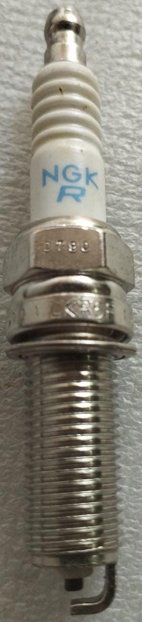 CarTrends spark plug LKR6D10E for vehicle engine, showing the metal tip and ceramic insulator in a close-up image.