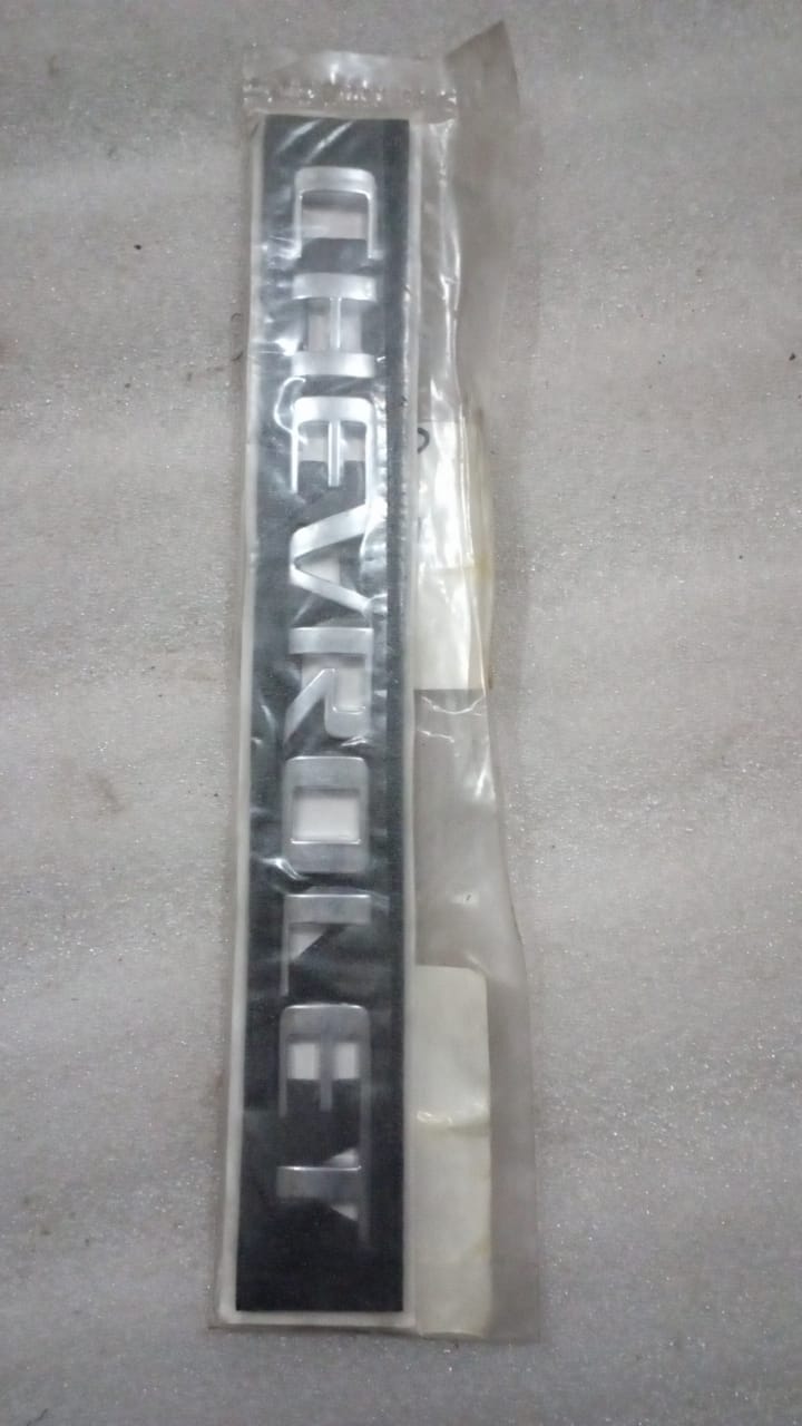 CarTrends Chevrolet Enjoy emblem plate with monogram design, suitable as a spare part for Chevrolet Tavera vehicles.