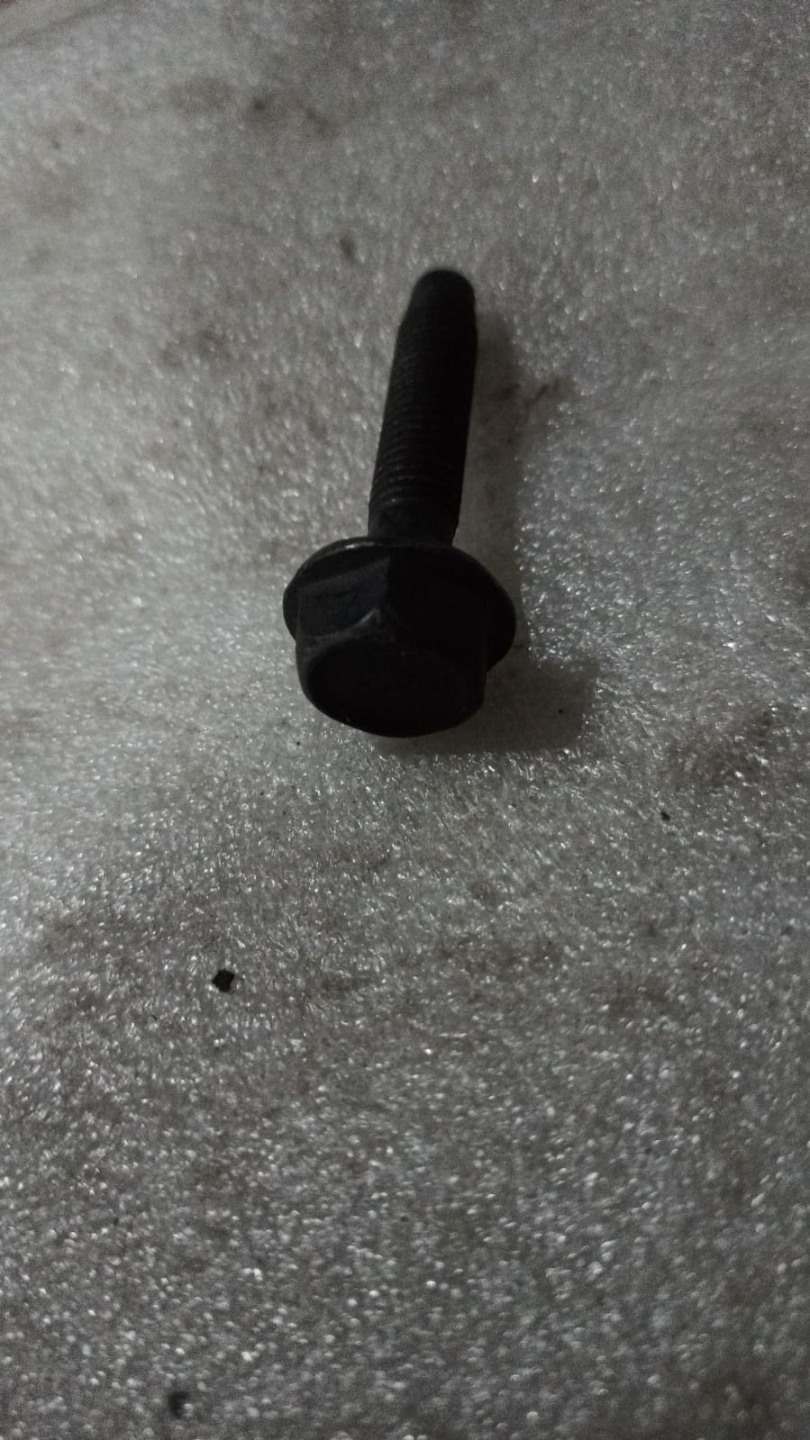 General Motors Bolt Beat engine part, close-up view showing metal component with detailed surface texture.