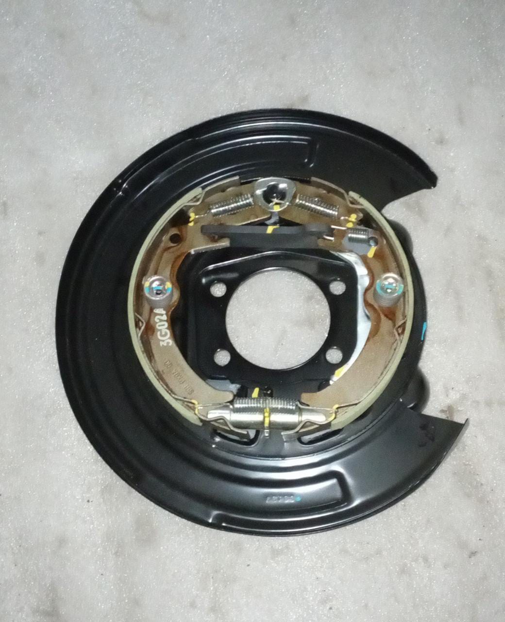 Rear left parking brake for Chevrolet Optra by General Motors, showing the brake component mounted on the vehicle's rear side.
