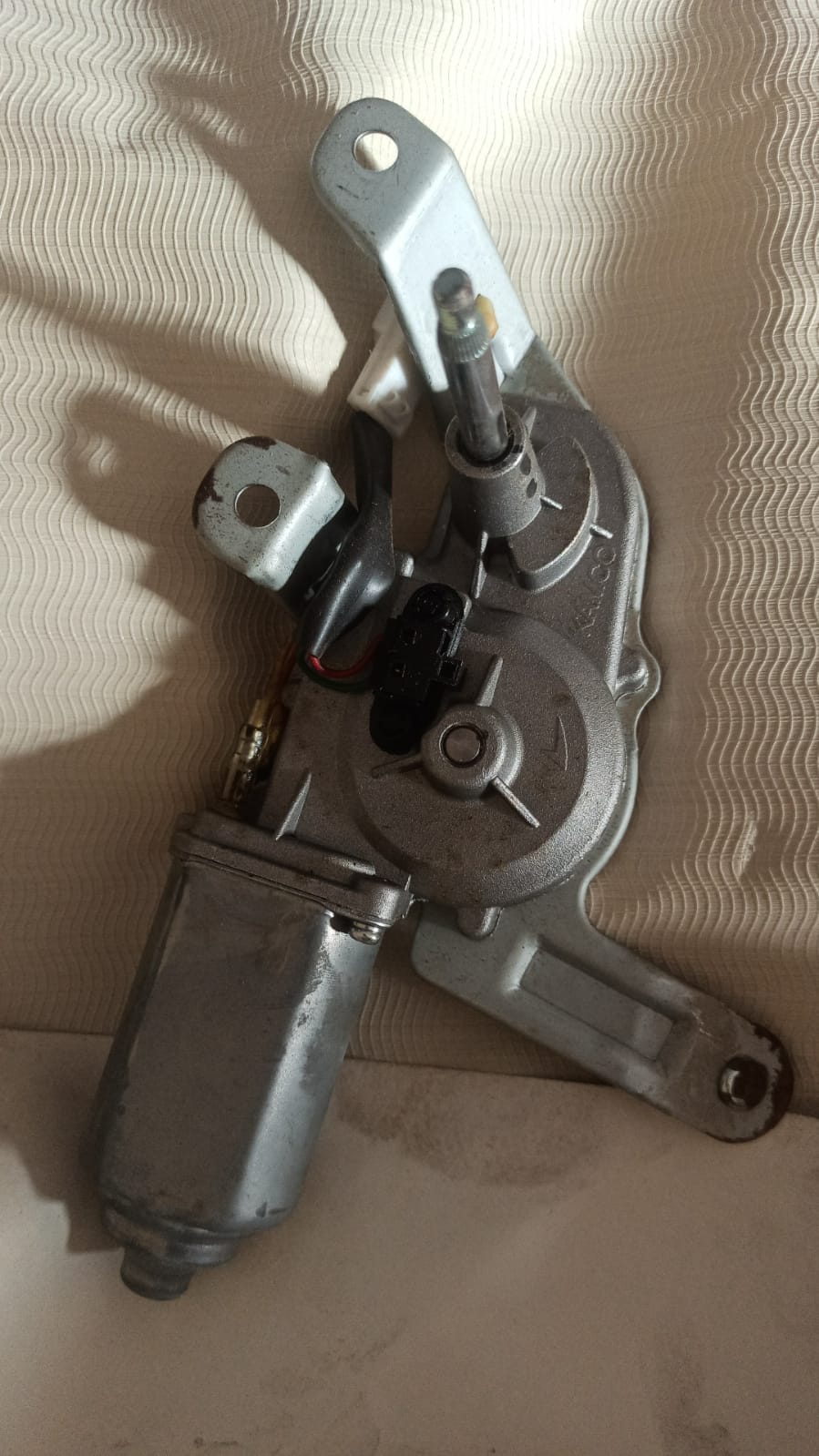 Rear motor wiper for Chevrolet Spark by General Motors, showing the replacement part with rubber blade and mounting arm.