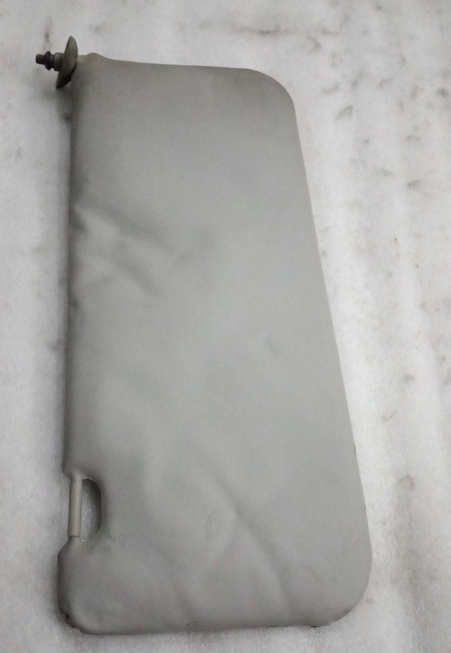 Chevrolet Tavera LH sun visor assembly by General Motors, without pocket, shown from the side in a vehicle interior.