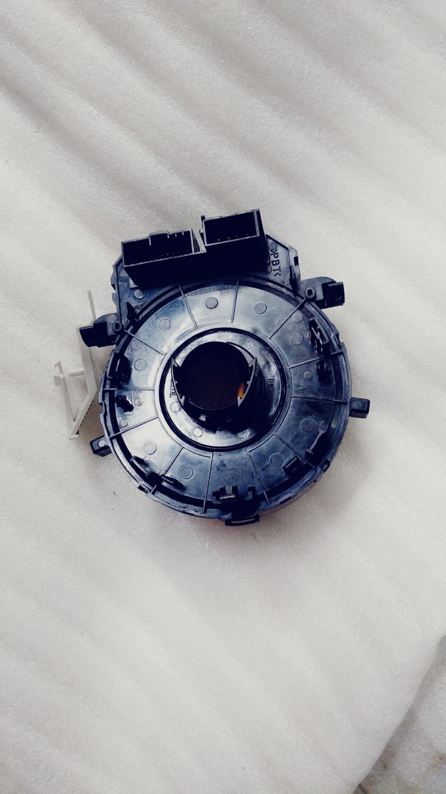 Hyundai clock spring for Kia Seltos, Sonet, and Carens, part number 93490S1130, shown on a vehicle dashboard.
