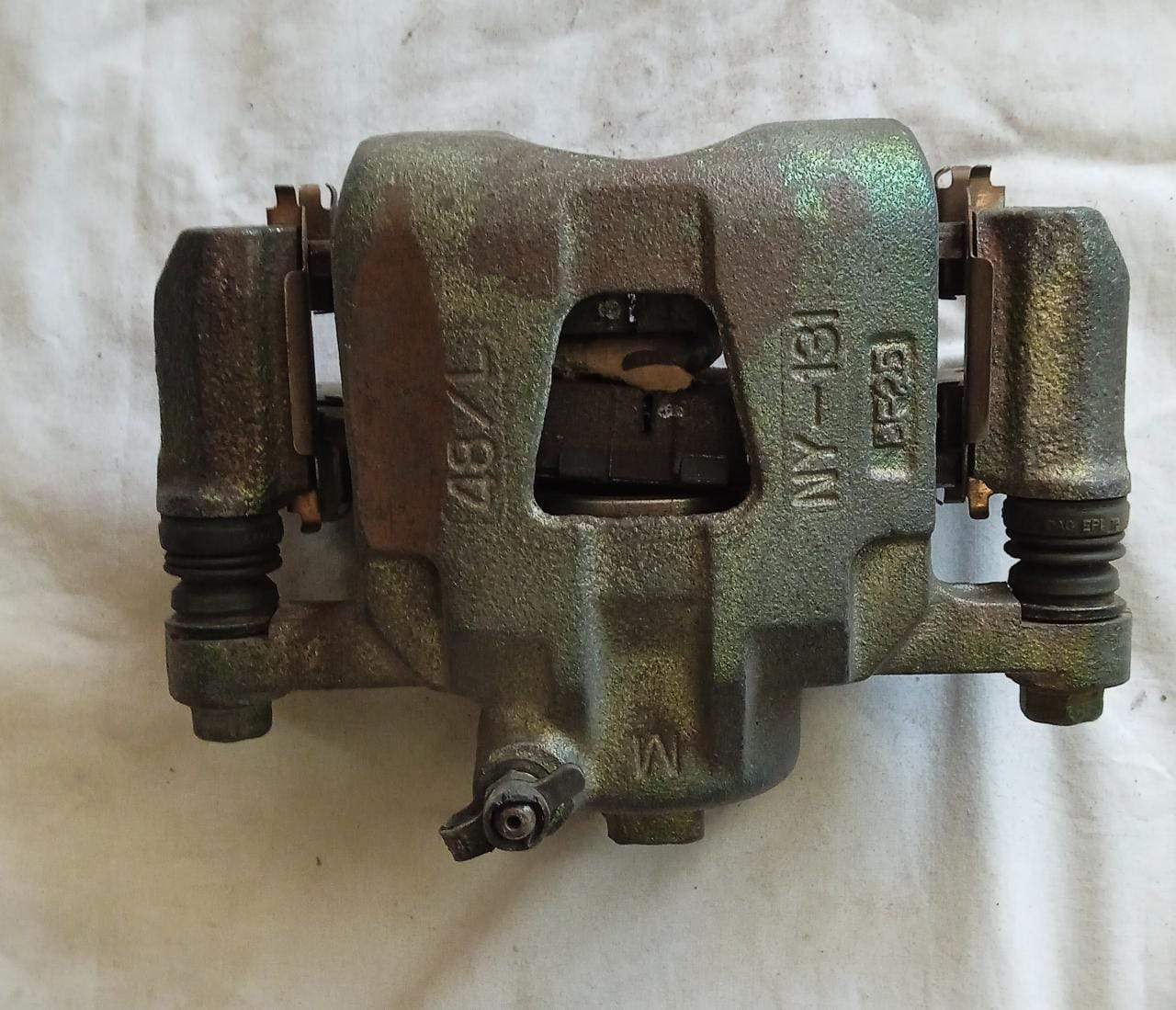 Local Caliper Matiz LH, car brake caliper component, shown in black with visible mounting points and detailed surface texture.