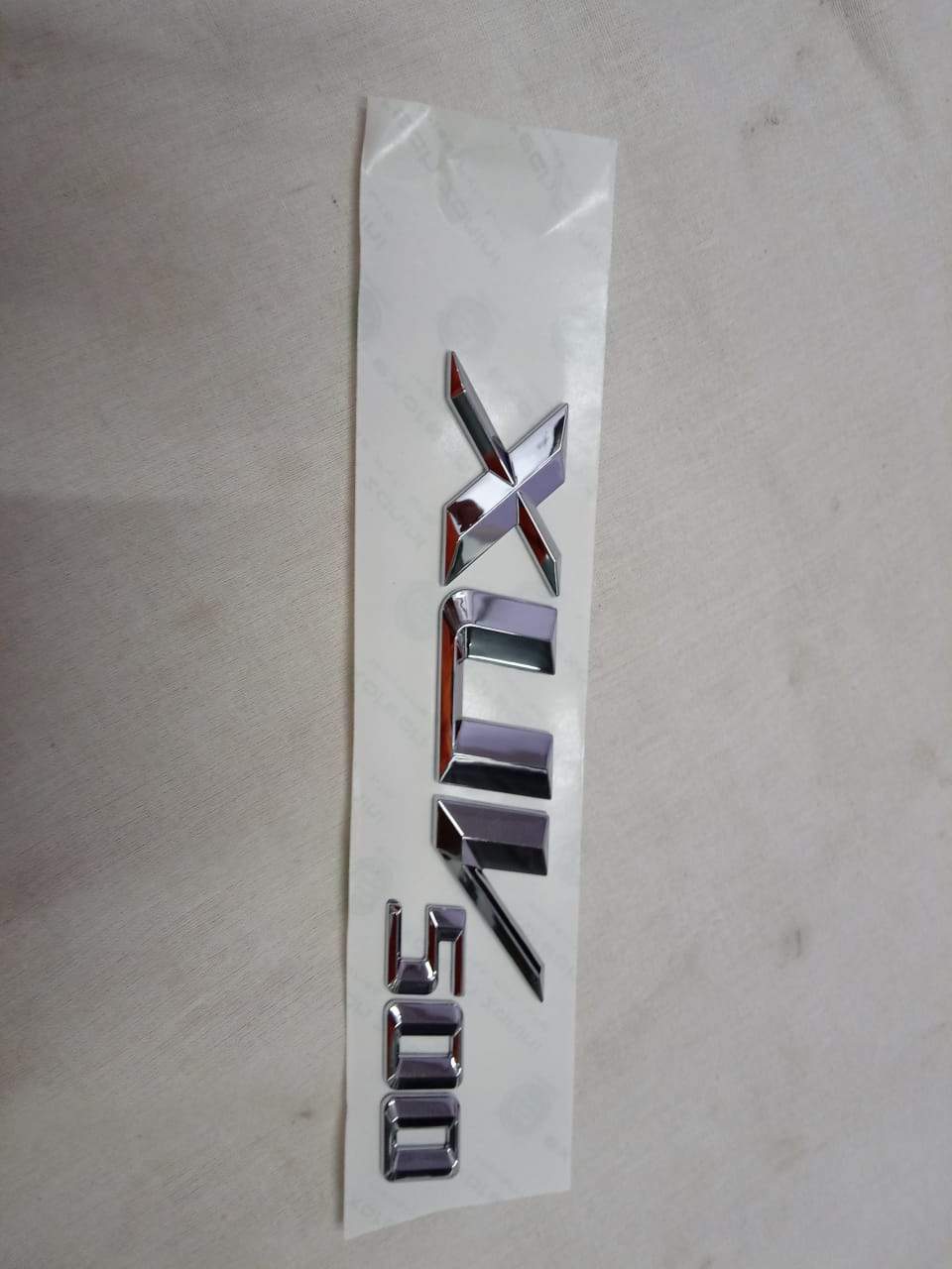 Mahindra Monogram XUV 500 badge on a Mahindra vehicle, showcasing the brand logo and model emblem on the car's exterior.